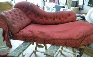 A chaise lounge in a real bad state before upholstery and frame repair